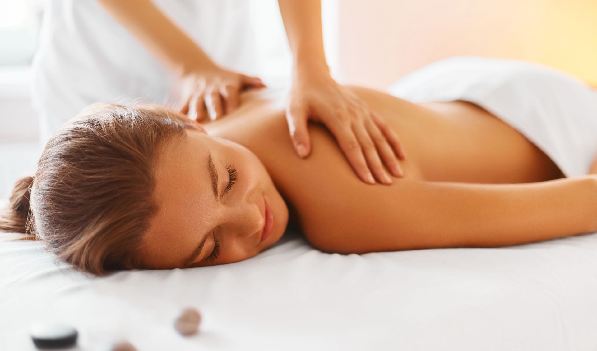 Client relaxing during a back massage on a treatment table